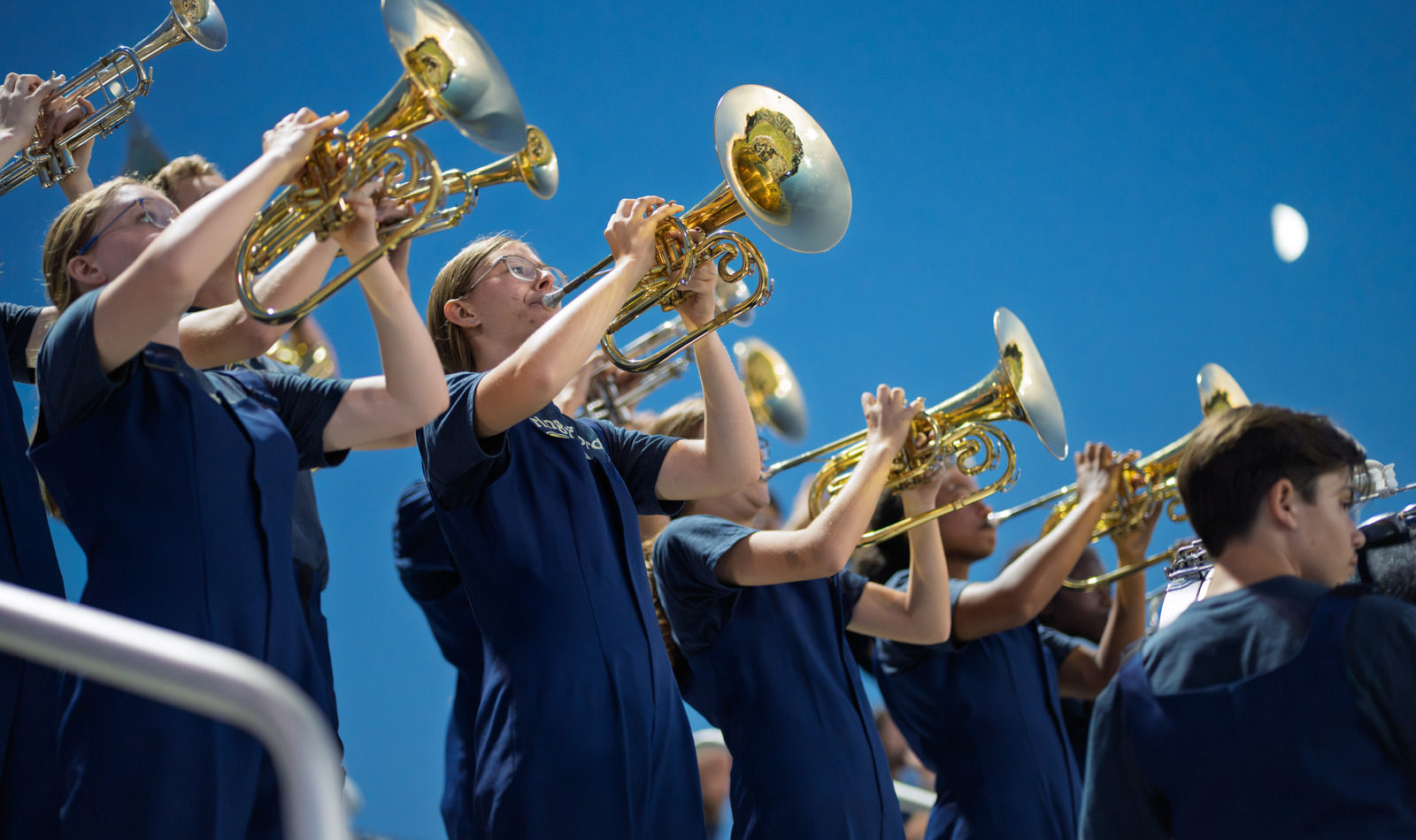 Spring-Ford student musicians performing with brass instruments under stadium lights